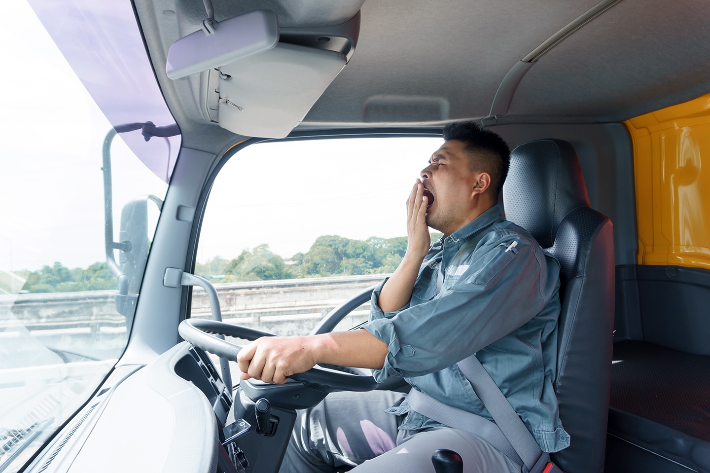 A tired man behind the wheel of a big rig