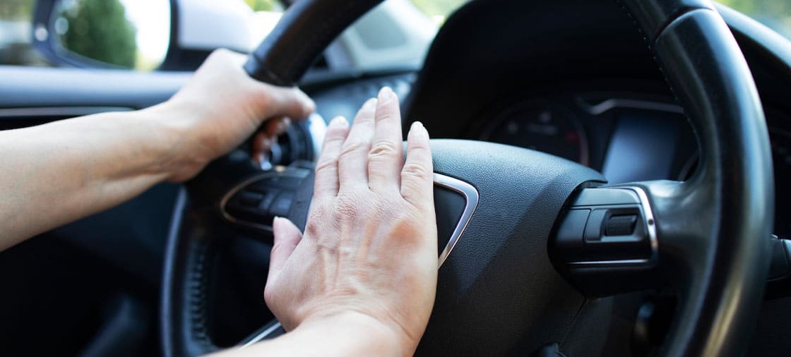 angry man honking horn during road rage incident against a motorcyclist