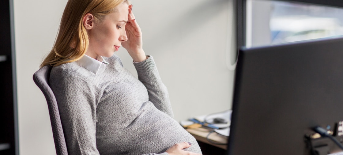 Lady distressed at work because she experienced pregnancy discrimination from coworkers.