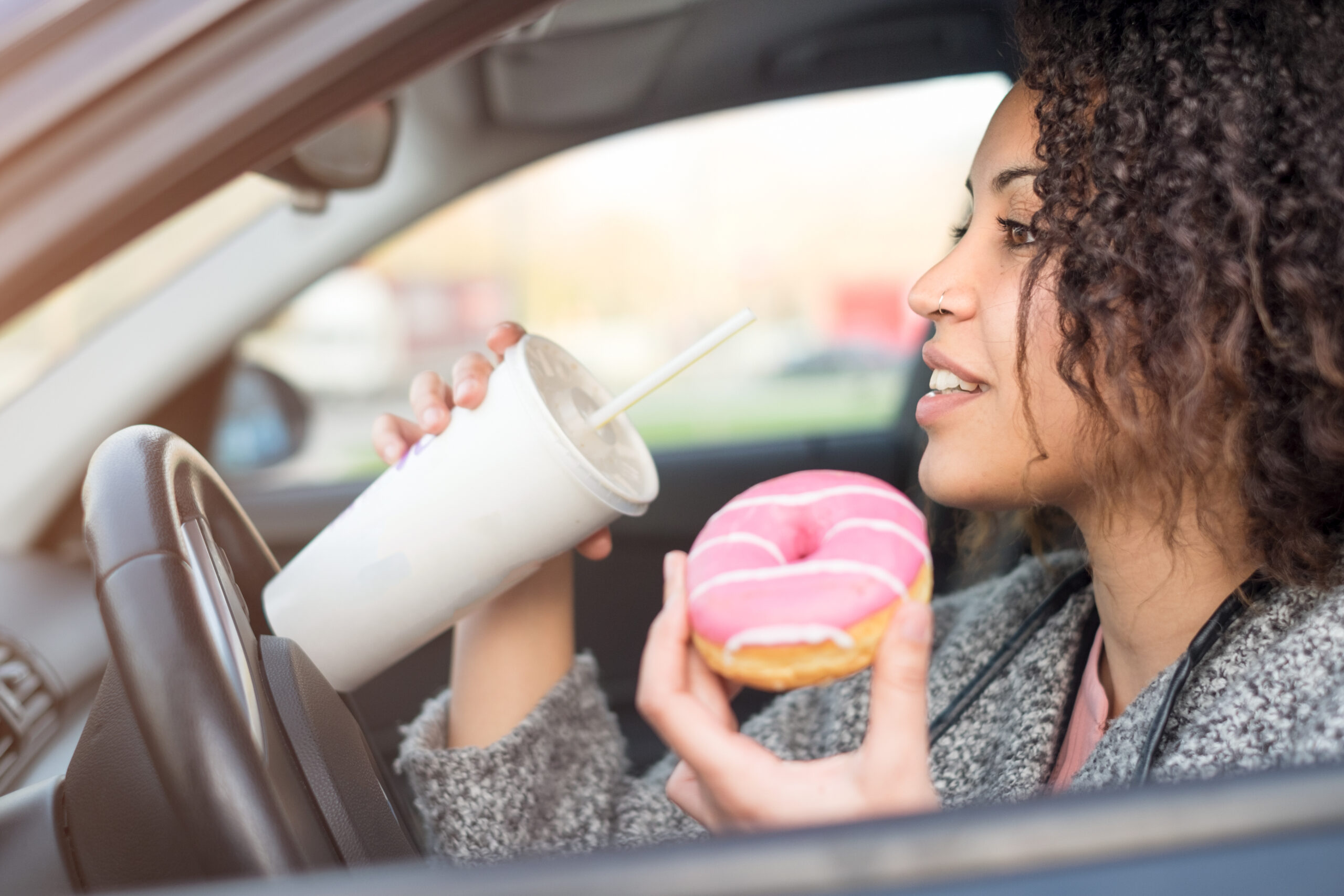 woman eating donut in car.