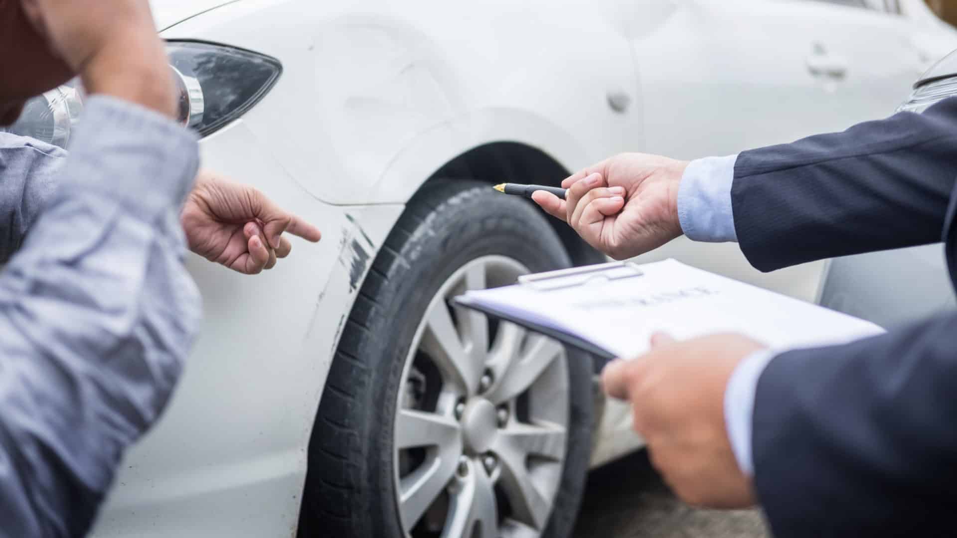 car insurance adjuster looking at damaged car