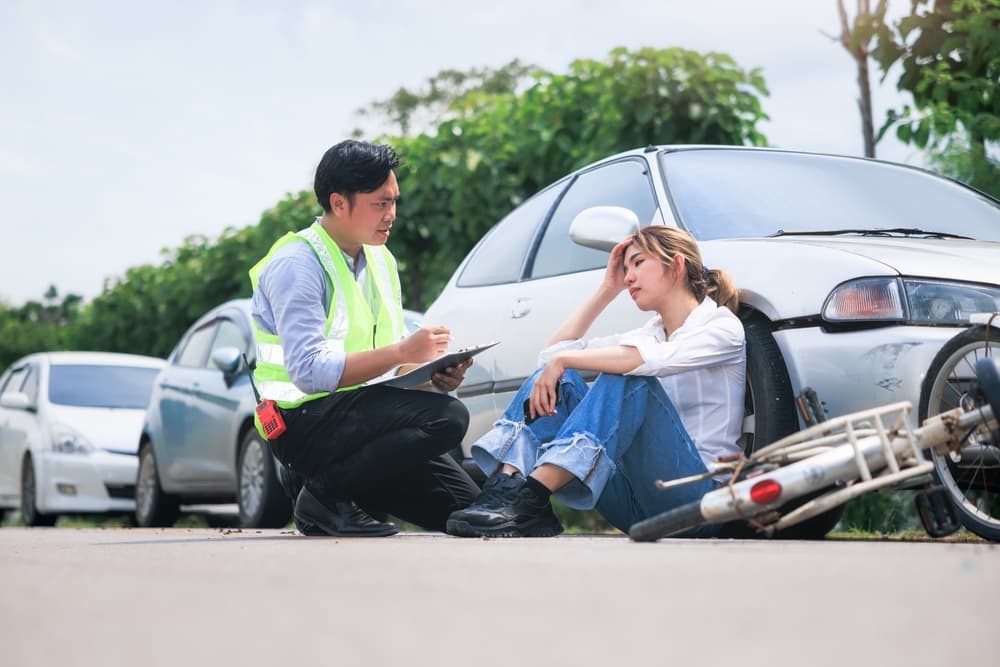 A women sitting on the road after the car accident