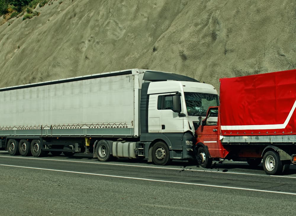 Frontal collision between two trucks, resulting in a road accident.