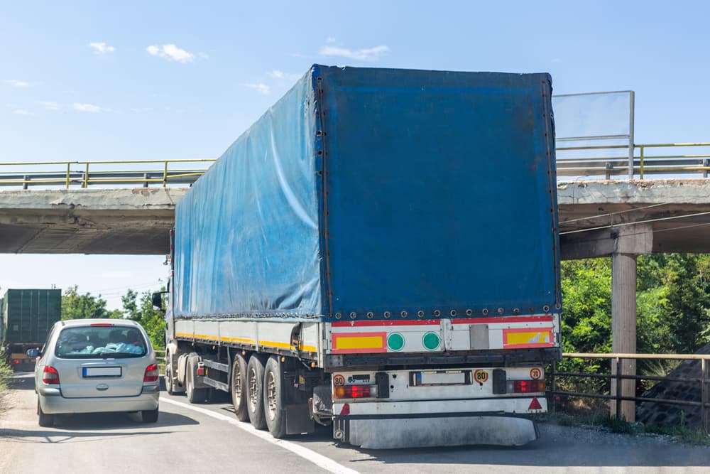 Truck collision with bridge as it cannot pass underneath due to height restriction.